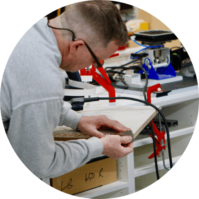 Kitchen factory worker trimming edge laminate